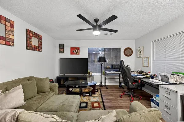 a living room with furniture and a flat screen tv with wooden floor