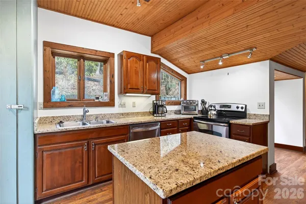 a kitchen with granite countertop sink and cabinets