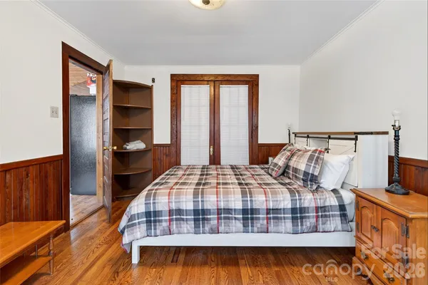 a bedroom with a bed and wooden floor