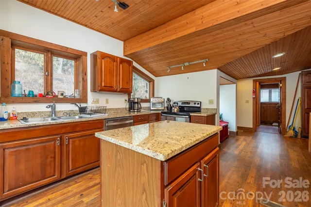 a kitchen with a stove sink and cabinets