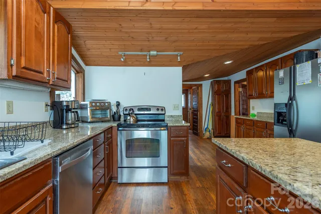 a kitchen with stainless steel appliances granite countertop a sink a stove and cabinets