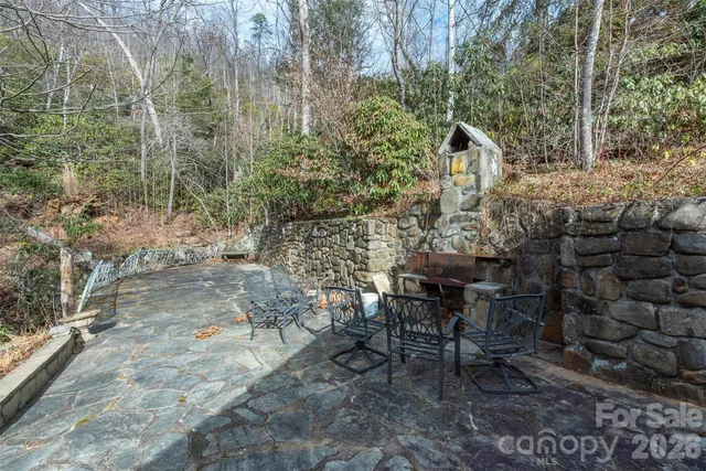 a view of a patio with table and chairs with wooden fence and plants