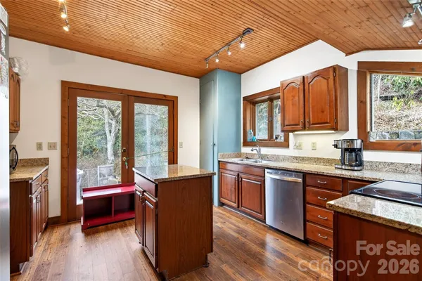 a kitchen with granite countertop a stove a sink and a refrigerator