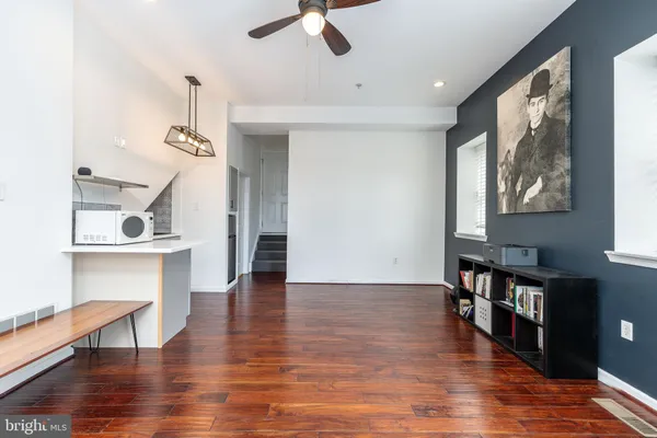 a view of empty room with wooden floor and fan