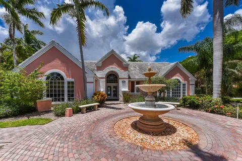 a front view of a house with a fountain and a fountain