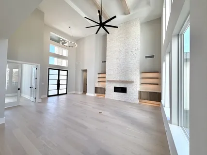 a view of an empty room with a fireplace and a window