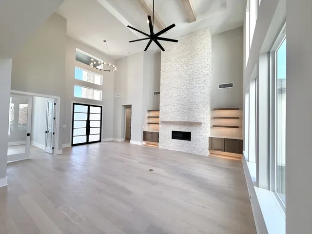 a view of an empty room with a fireplace and a window