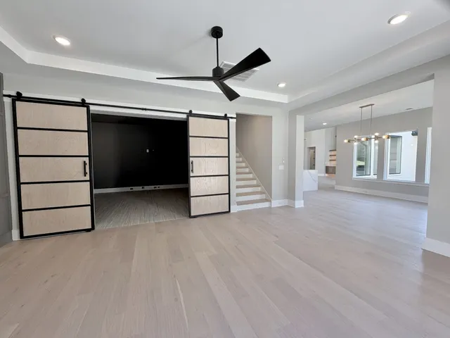 a bedroom with a bed and large windows