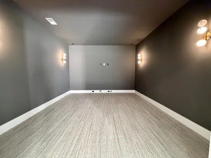 an empty room with wooden floor ceiling fan and windows