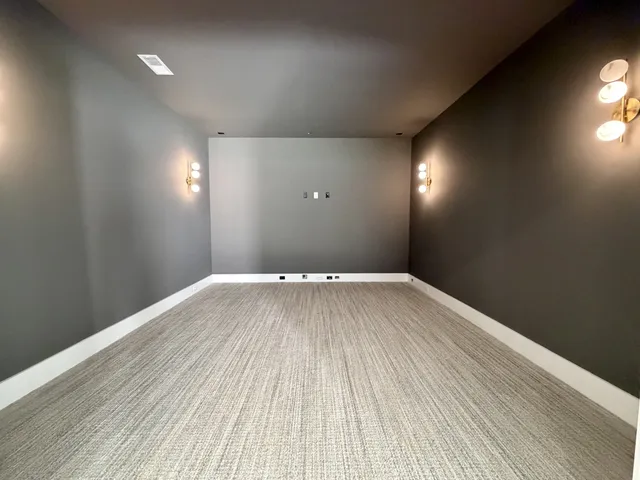 an empty room with wooden floor ceiling fan and windows