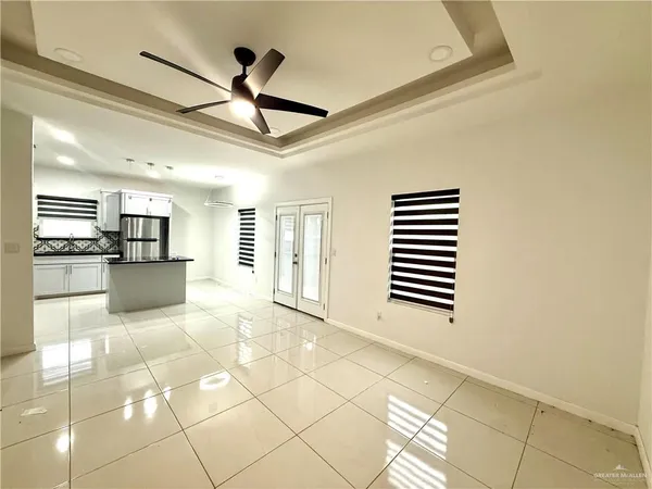 a view of empty room with wooden floor and ceiling fan