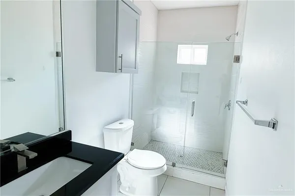a bathroom with a granite countertop toilet and a shower