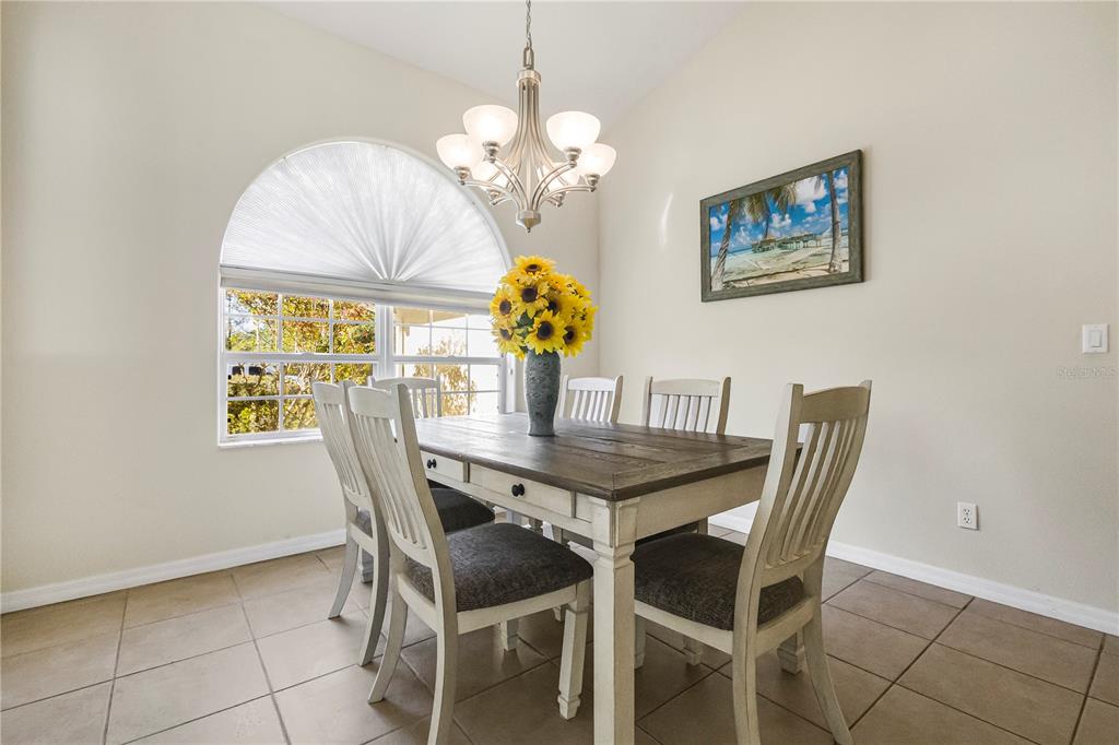 24 Regency Drive Palm Coast, FL 32164 - Photo 11 of 36 a dining room with furniture a rug and a chandelier
