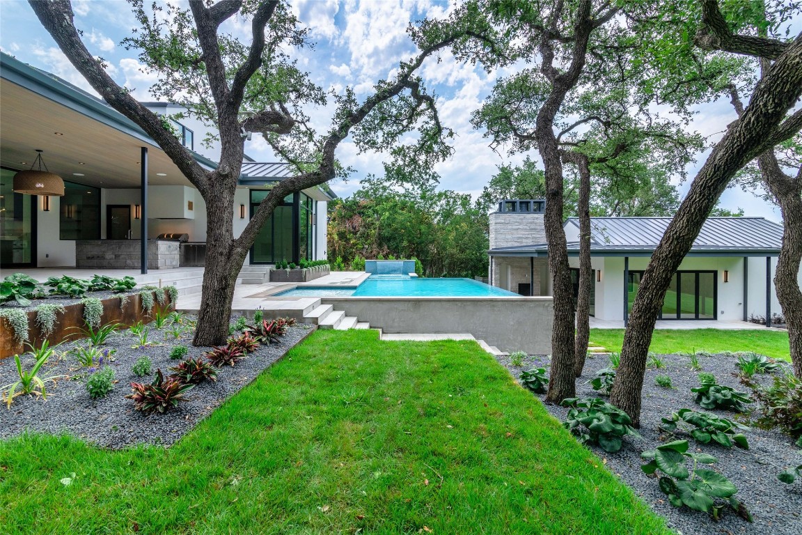 a front view of a house with garden and a tree
