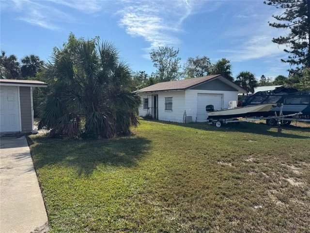 a view of a house with backyard and trees