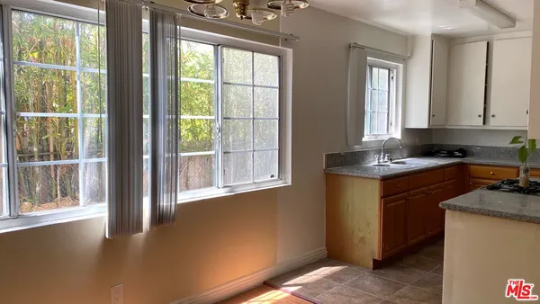 a kitchen with granite countertop a stove a sink and a window