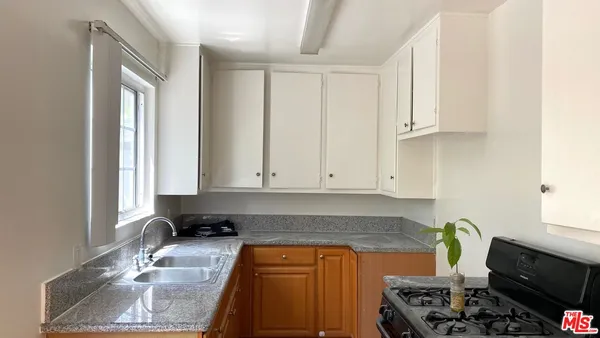 a kitchen with stainless steel appliances granite countertop a sink stove and cabinets