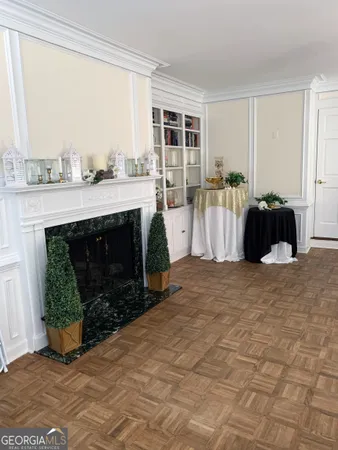 a view of a hallway with wooden floor and a living room
