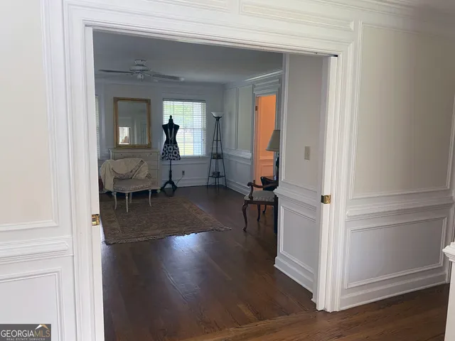 a view of a hallway with wooden floor and staircase