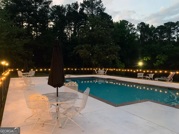 a view of a swimming pool with an outdoor seating and a yard