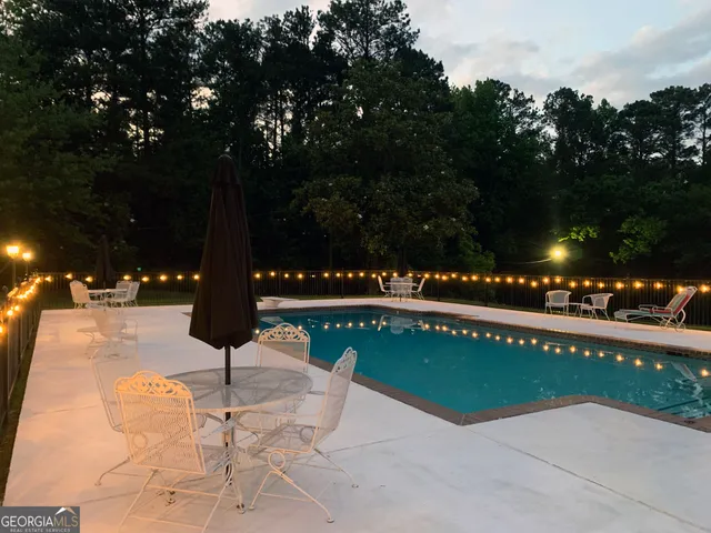a view of a swimming pool with an outdoor seating and a yard