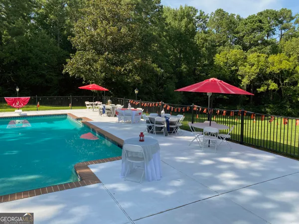 a view of a patio with a table and chairs under an umbrella