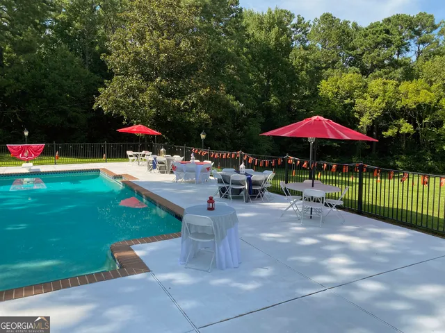 a view of a patio with a table and chairs under an umbrella