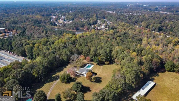 an aerial view of residential house with yard and mountain view in back