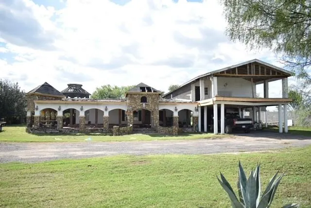 a front view of a house with a yard and trees