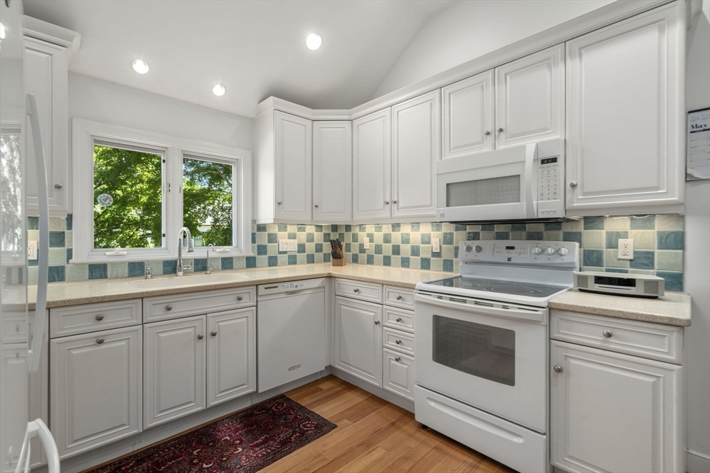 127-129 Withington Road Newton, MA 02460 - Photo 8 of 33 a kitchen with granite countertop white cabinets and white appliances