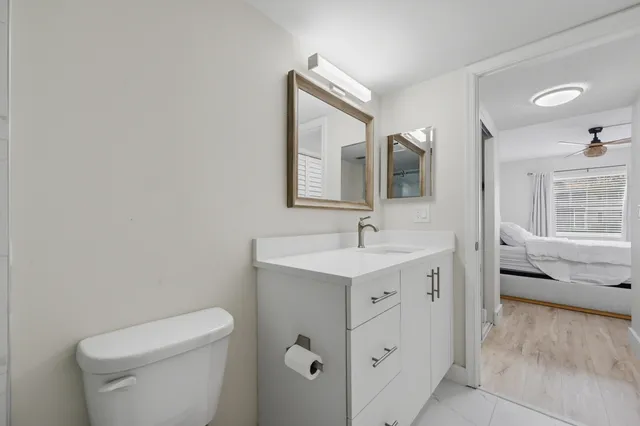 a bathroom with a sink toilet vanity and shower