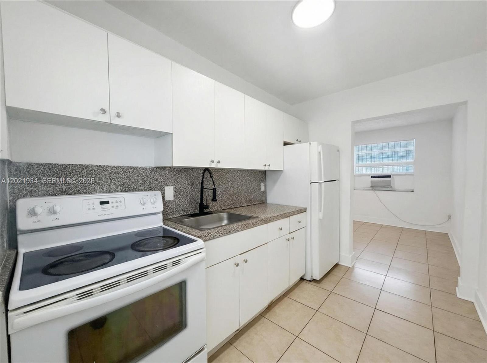 220 Northwest 11th Terrace, Unit 2 Miami, FL 33136 - Photo 4 of 9 a kitchen with a stove top oven and cabinets