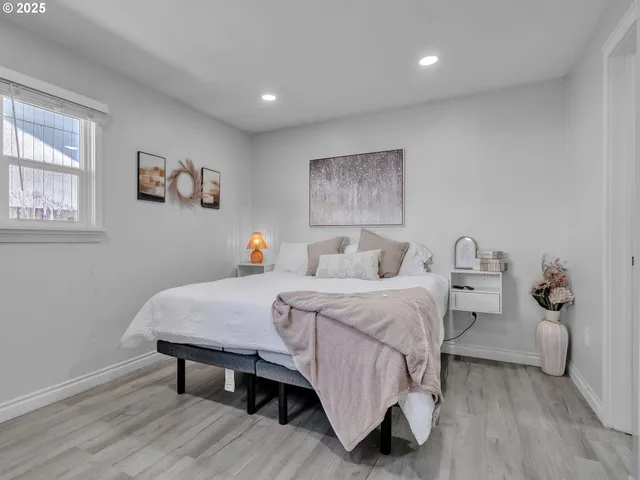 a bedroom with a bed and wooden floor