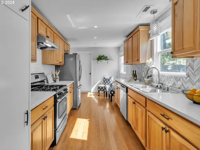 a kitchen with wooden floor a sink a stove and a wooden floors