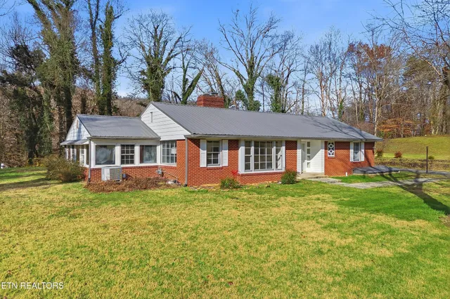 a front view of a house with a yard and trees