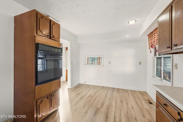a view of an empty room and a kitchen