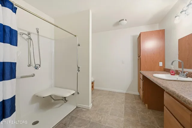a bathroom with a granite countertop sink a toilet and shower