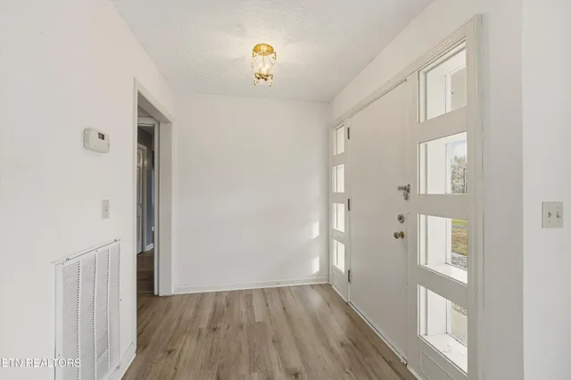 a view of a hallway with wooden floor and closet