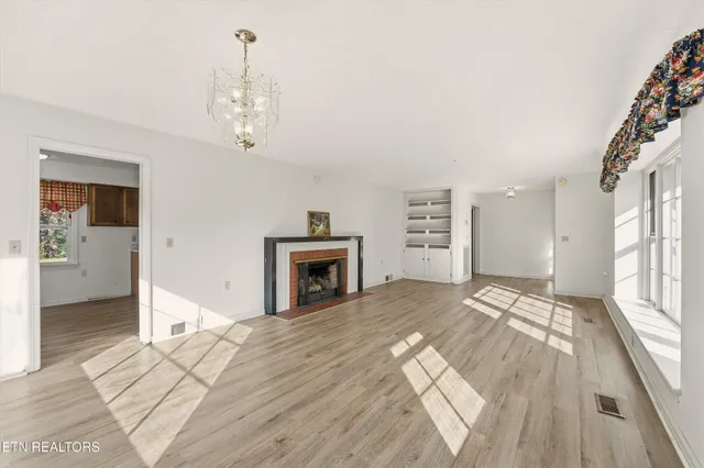 a view of an empty room with a fireplace and a window