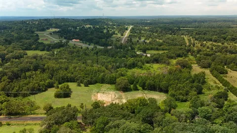 an aerial view of residential houses with outdoor space and trees