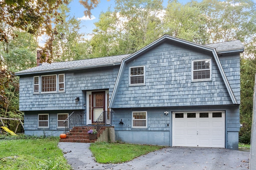 77 Hunt Road Chelmsford, MA 01824 - Photo 1 of 36 a front view of a house with a garden and garage