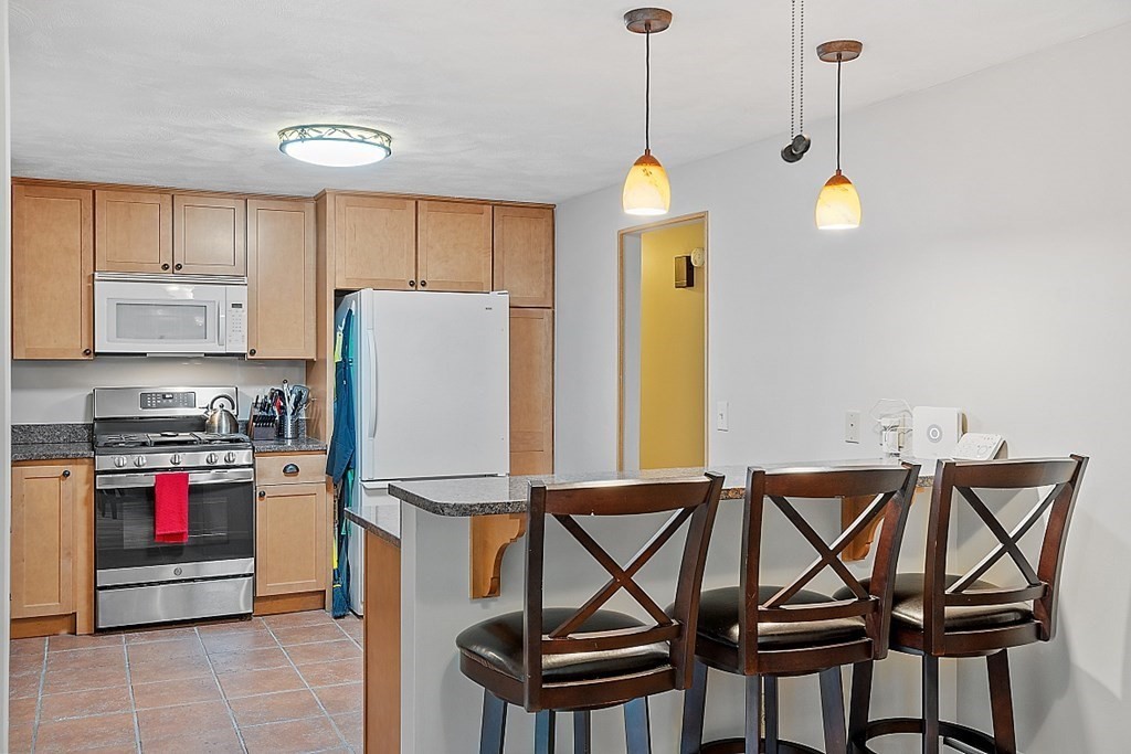 77 Hunt Road Chelmsford, MA 01824 - Photo 7 of 36 a view of a kitchen with a dining table and chairs