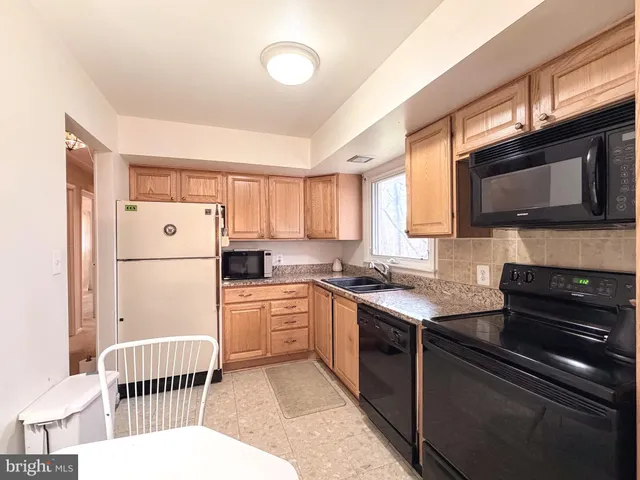 a kitchen with granite countertop a sink and a stove top oven