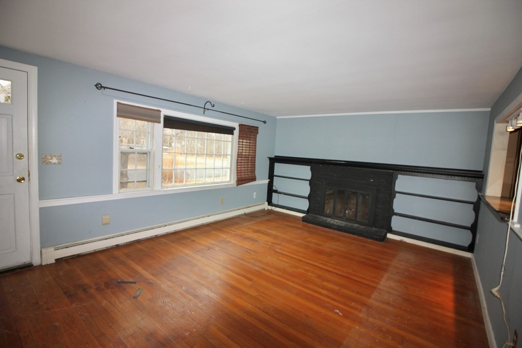 4 Thach Lane Barnstable, MA 02601 - Photo 2 of 18 a view of an empty room with wooden floor fireplace and a window