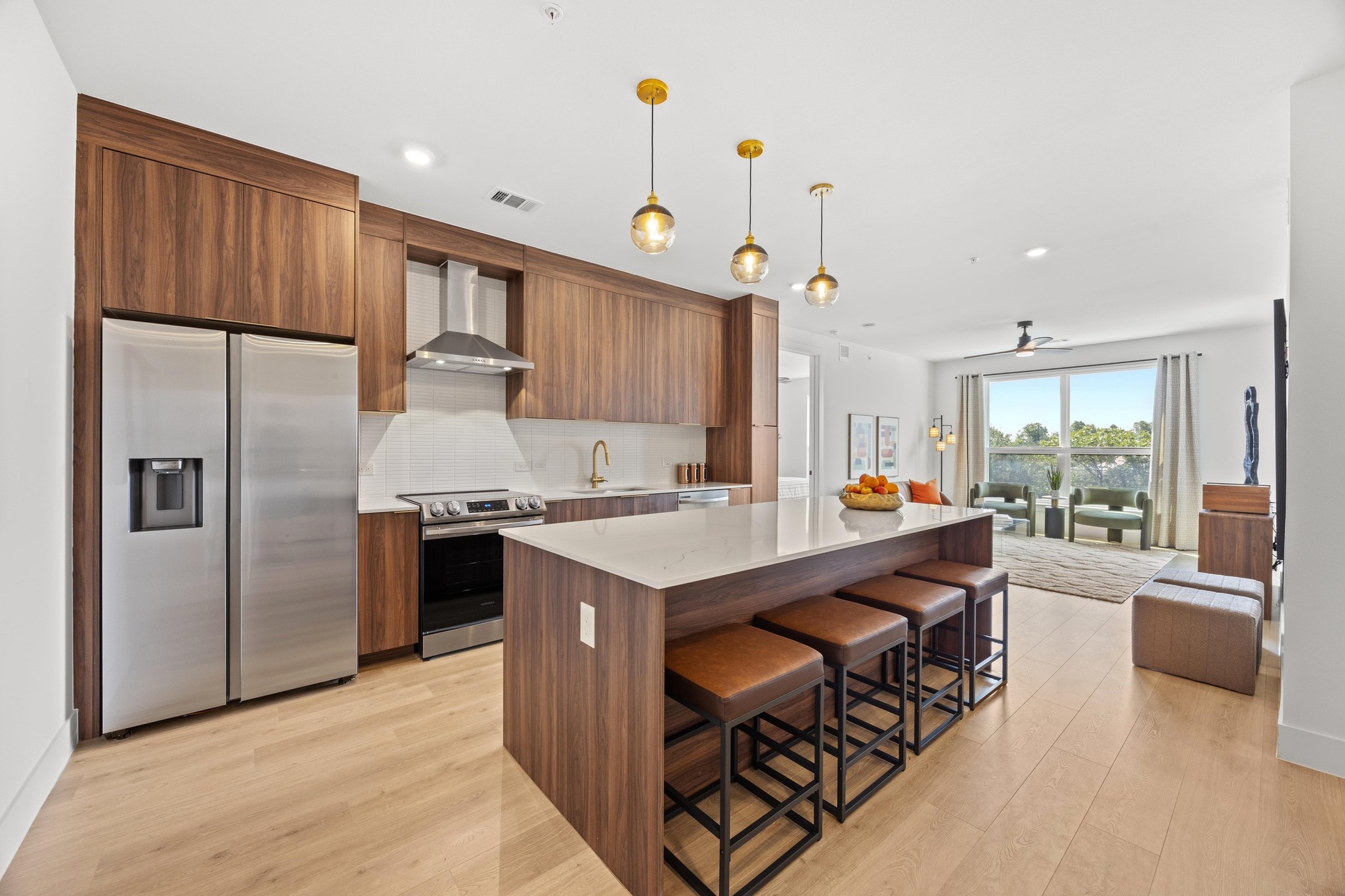 a kitchen with stainless steel appliances granite countertop a refrigerator a sink dishwasher a stove and a refrigerator with wooden floor