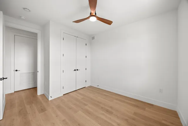 a view of an empty room with chandelier fan