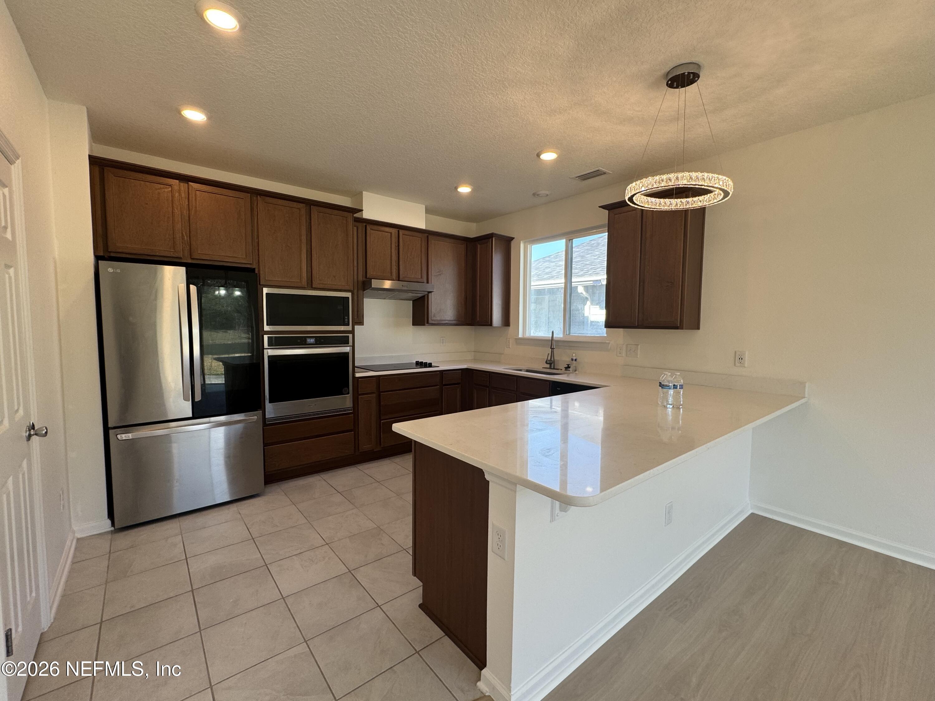 310 Rambling Brk Trail St. Johns, FL 32259 - Photo 23 of 28 a kitchen with stainless steel appliances granite countertop a refrigerator a sink a stove a microwave and island