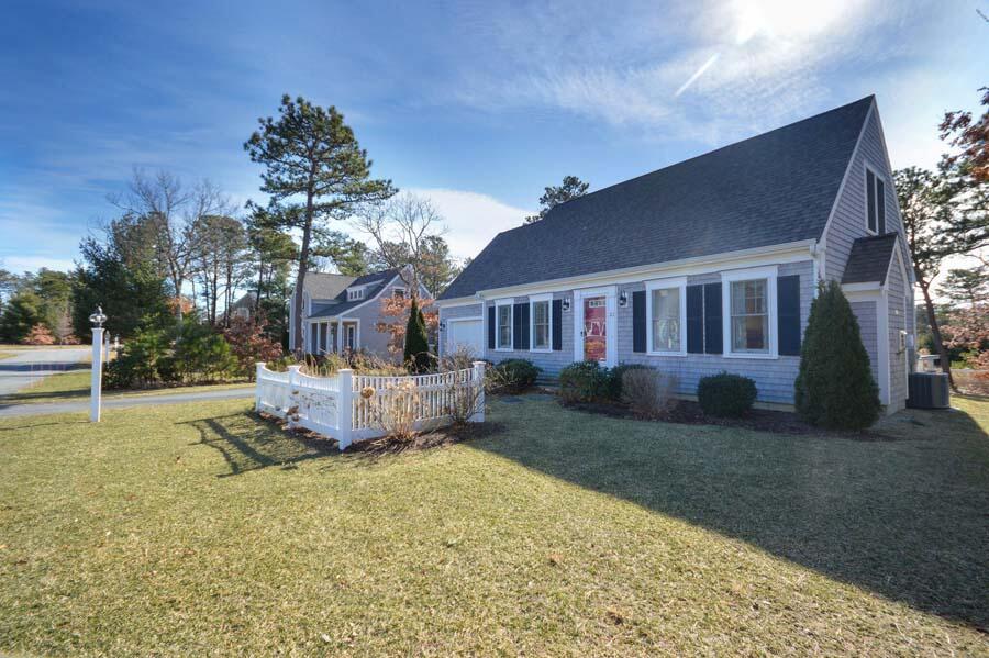 21 Dovetail Lane Cotuit, MA 02635 - Photo 2 of 30 a front view of a house with a garden and yard
