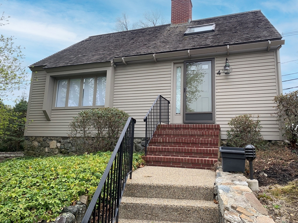 a view of house with wooden deck and furniture