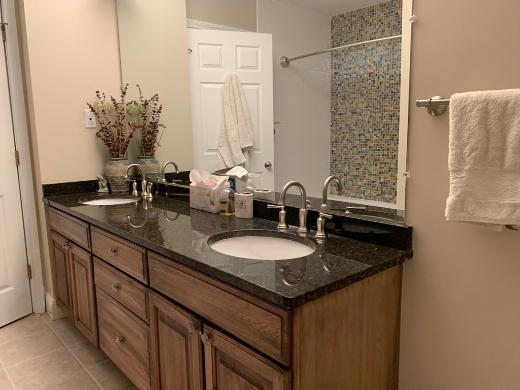 4 Potter Pond, Unit 4 Lexington, MA 02421 - Photo 14 of 15 a bathroom with a granite countertop sink and a mirror